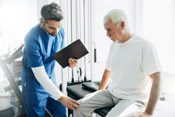 Pain management doctor exam patient's knee.