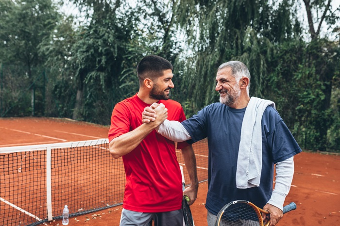 Two friends handshake after tennis game