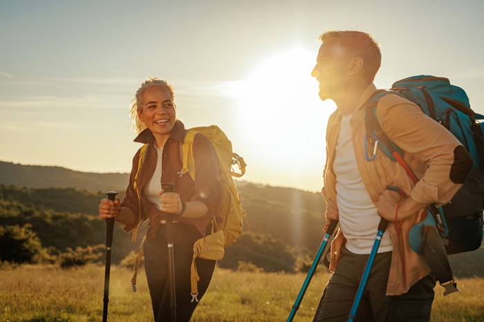Middle age couple using hiking poles, hiking