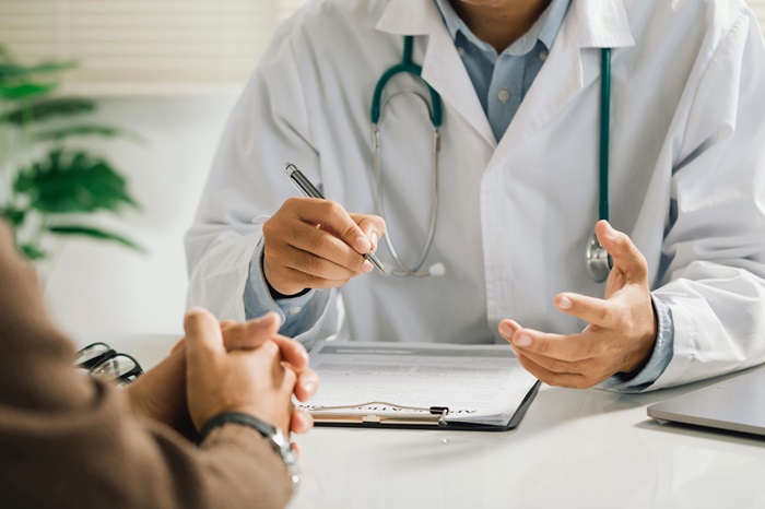 A physician discusses a condition with a patient.