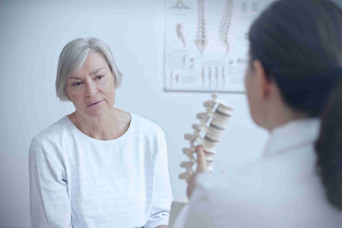 Woman consulting with doctor about lumbar compression fracture