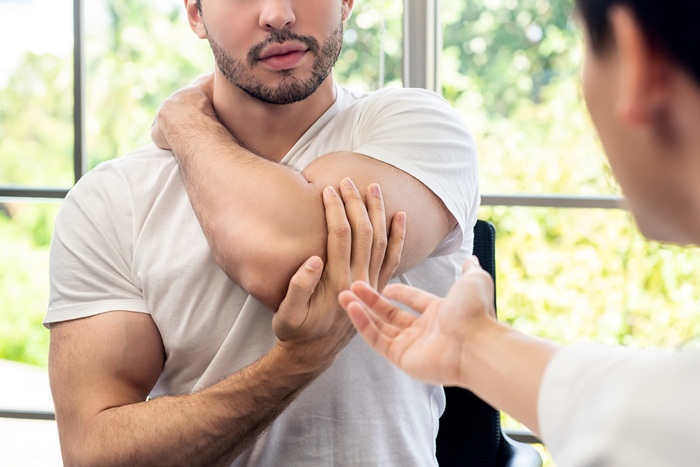 Doctor treating an patient's injured elbow