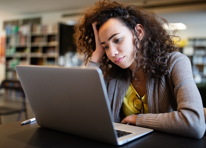 Adult working on a laptop in a library