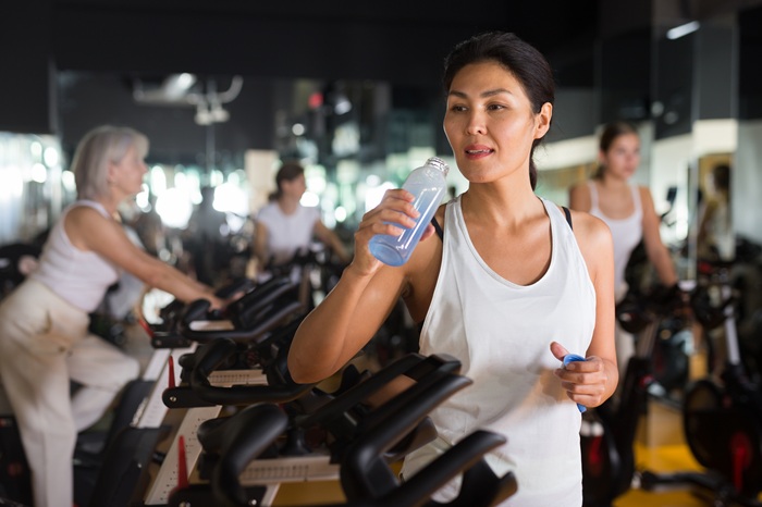 Woman rehydrating after spin class