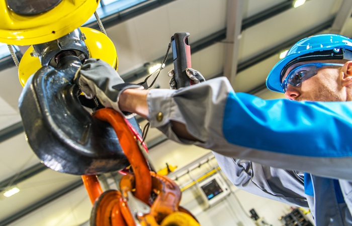 Factory worker lifting heavy over head