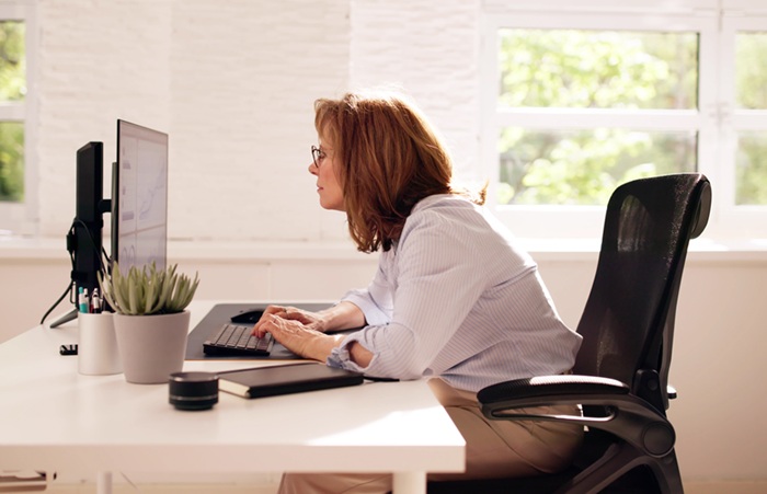 Woman working at her desk with poor posture