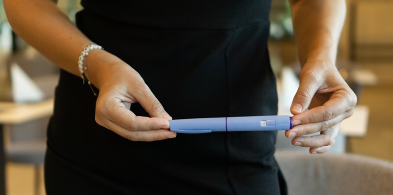 Woman holding a GLP-1 weight loss injection